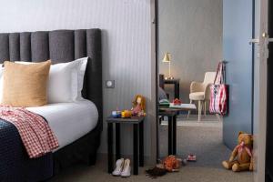 a bedroom with a bed and two tables with stuffed animals at Best Western Plus H&ocirc;tel Isidore in Saint-Jacques-de-la-Lande