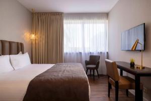 een hotelkamer met een bed en een bureau bij Best Western Plus Hôtel Isidore in Saint-Jacques-de-la-Lande