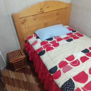 ein Bett mit einer Bettdecke mit Rosen darauf in der Unterkunft Agradable minidepartamento central en Ambato, para una a seis personas in Ambato