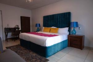 a bedroom with a large bed with a blue headboard at Artea Hotel Boutique in Guadalajara
