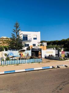 a white building with a fence on the side of a street at Surf house apartment in Oualidia