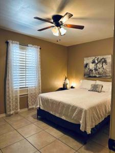 1 dormitorio con 1 cama y ventilador de techo en Western Style - 2 bed/1 bath (RATED 10 STARS), en Eagle Pass