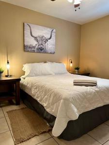 1 dormitorio con 1 cama con una foto de un toro en Western Style - 2 bed/1 bath (RATED 10 STARS), en Eagle Pass