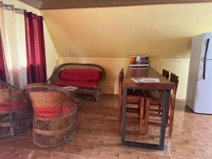 ein Esszimmer mit einem Tisch und Stühlen sowie einem Kühlschrank in der Unterkunft Cabaña Las Colinas in Bijagua