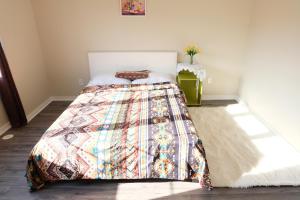 um quarto com uma cama com uma colcha colorida em 壹家民宿 em Markham
