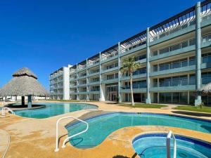 een groot gebouw met een zwembad voor een gebouw bij Unwind in a Modern Condo with Stunning View in Puerto Peñasco