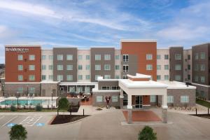 a large building with a pool in front of it at Residence Inn by Marriott Dallas Grand Prairie in Grand Prairie