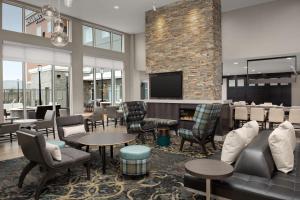 a lobby with chairs and tables and a fireplace at Residence Inn by Marriott Dallas Grand Prairie in Grand Prairie