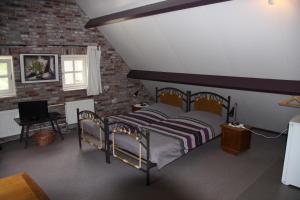 een slaapkamer met een bed en een bakstenen muur bij Appartement Hoeve Polsdonk in Oirschot