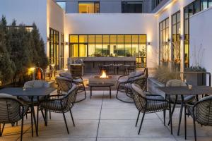 a patio with tables and chairs and a fire pit at Element Bozeman in Bozeman