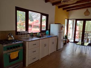 a kitchen with a stove and a refrigerator at Luna Jatun in Purmamarca +27 photos