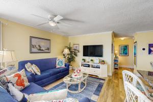 a living room with a blue couch and a tv at Tressa Terrace in Avon