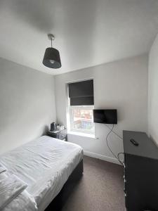 a white bedroom with a bed and a window at SELF CHECK IN APARTMENT DONCASTER in Doncaster