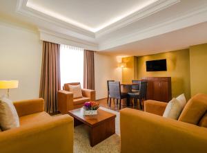 a hotel room with chairs and a dining room at Hotel Veracruz Centro Histórico in Veracruz