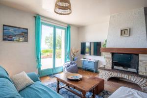 a living room with a blue couch and a fireplace at La Belle Étoile - Maison de campagne - 8 pers in Yport