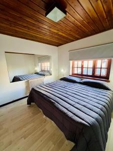 a bedroom with a large bed with a wooden ceiling at Casa andina in Esquel