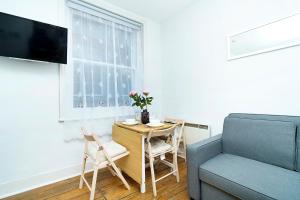 ein Wohnzimmer mit einem Tisch und einem Sofa in der Unterkunft Brewer Street Central Apartments in London