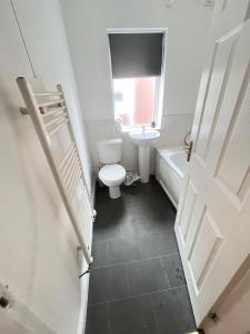 Baño blanco con aseo y lavamanos en SELF CHECK IN APARTMENT DONCASTER en Doncaster