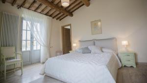 um quarto com uma cama, uma cadeira e uma janela em Casale Galli em Trevinano