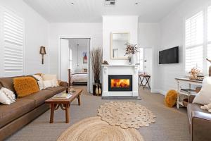 un soggiorno con divano e camino di The Hidden Door Bowral Cottage - The Love of Bowral a Bowral