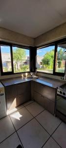 a kitchen with three windows and a counter top at Departamentos Merceditas in San Rafael