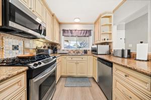 uma cozinha com armários de madeira e um forno com placa de fogão em San Jose 4BR Sweet Home Prime Location - 2 Master BR em San José