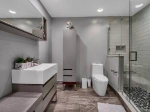 y baño con lavabo, aseo y ducha. en 3 Bedrm Palace Suite - King FL bed & Free EV Charging, en Orlando