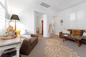 un soggiorno con un divano e un tavolo di The Hidden Door Bowral Cottage - The Love of Bowral a Bowral