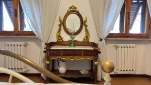 um relógio sobre uma mesa com um espelho sobre ele em CASA GIOVANNI em San Gimignano