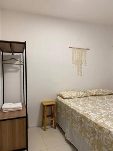 a bedroom with a bed and a table and a chandelier at Cariri Vivenda - Apto completo com 02 quartos climatizados, estacionamento e portaria 24 horas in Juazeiro do Norte