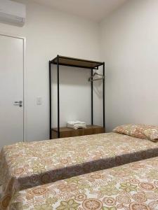 1 Schlafzimmer mit 2 Betten und einem Spiegel in der Unterkunft Cariri Vivenda - Apto completo com 02 quartos climatizados, estacionamento e portaria 24 horas in Juazeiro do Norte