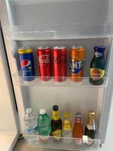 a refrigerator filled with cans and bottles of soda at Cleli in Giardini Naxos