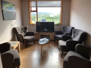 a waiting room with chairs and a flat screen tv at Bakkaflöt Guesthouse in Varmahlid