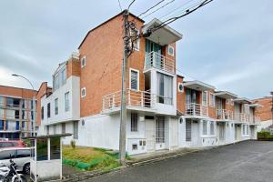 a large brick building with white windows and a street at Encantadora Casa en Eje Cafetero in Dosquebradas