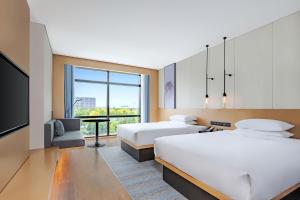 a hotel room with two beds and a tv at Fairfield by Marriott Beijing Daxing Airport in Beijing
