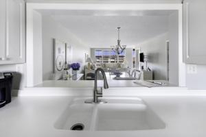a white kitchen with a sink and a mirror at Loggerhead 314 condo in Sanibel