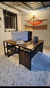 un escritorio con ordenador en una habitación en Hammock Hostels - Bandra en Bombay