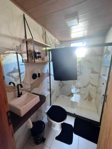 een kleine badkamer met een wastafel en een toilet bij Chalé de Madeira, a 60m do mar em condomínio in Vera Cruz de Itaparica