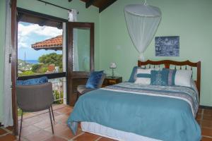 a bedroom with a bed and a balcony with a view at Calypso Court - Private 1 bedroom villa with pool villa in Cap Estate
