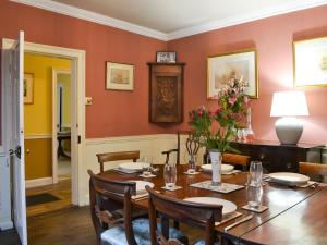 uma sala de jantar com uma mesa de madeira e cadeiras em Craven House em Bridlington