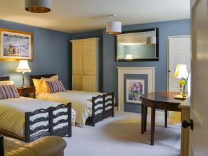 um quarto com 2 camas, uma mesa e um espelho em Craven House em Bridlington