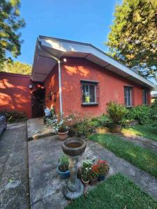 a red house with a flower garden in front of it at El paraíso de Apaneca in Apaneca