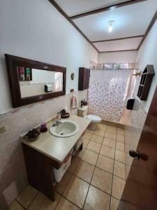 a bathroom with a sink and a toilet and a mirror at El paraíso de Apaneca in Apaneca