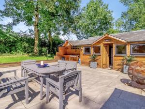 a patio with a table and chairs and a cabin at Dai Boy Cabin - Uk46403 in Cowbridge