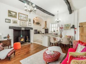 a living room with a fireplace and a table and chairs at Llwynhelig House - Uk46395 in Cowbridge