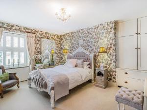 a bedroom with a bed and floral wallpaper at Llwynhelig House - Uk46395 in Cowbridge