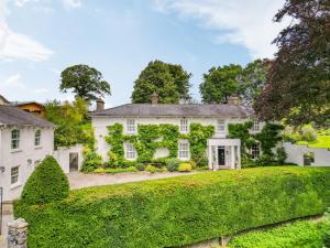 an exterior view of a white house with ivy at Llwynhelig House - Uk46395 in Cowbridge