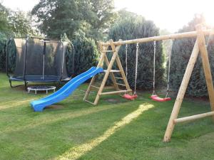 a playground with two swings and a slide at Holiday home near Husum secluded in Oster Wittbekfeld