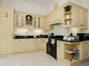 uma cozinha com armários de madeira e electrodomésticos pretos em Royal Crescent Apartment em Bath