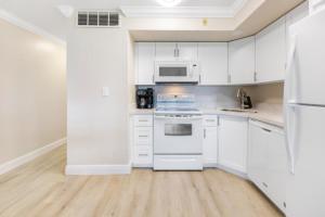 Biała kuchnia z białymi urządzeniami i białymi szafkami w obiekcie South Seas Bayside Villa 5226 condo w mieście Captiva